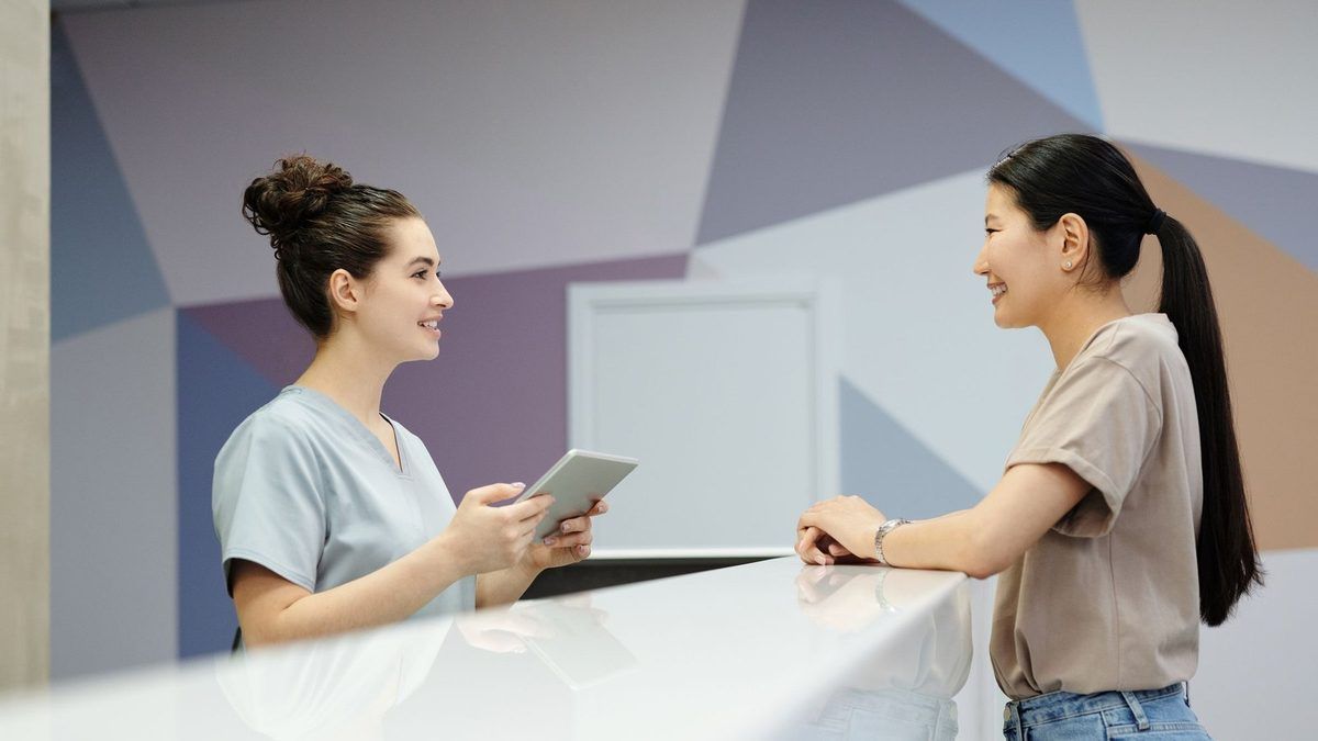 A receptionist helping a client at a front desk
