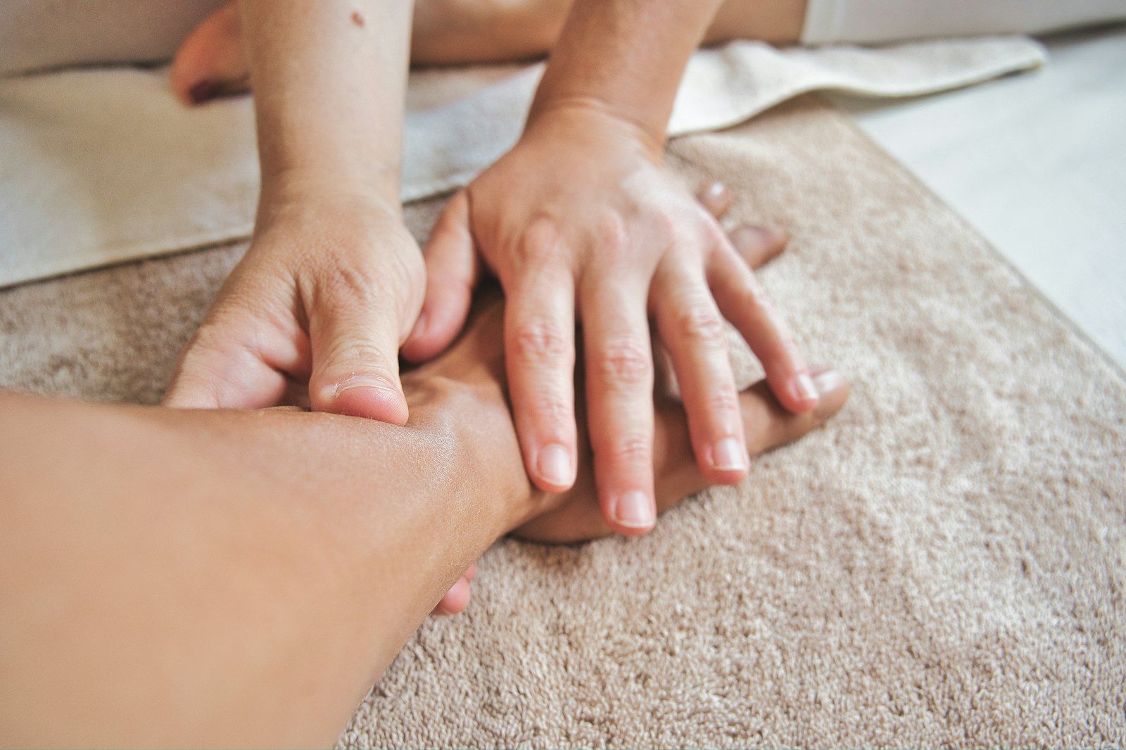 A therapist's hands working on a client's forearm