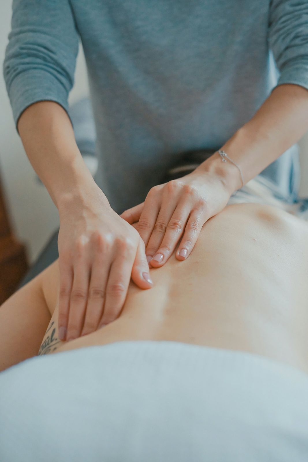 A therapist's hands working on a client's back